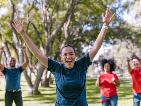 The image shows people celebrating in a a park.